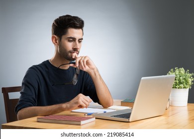 Handsome University Student Working On Laptop At Home