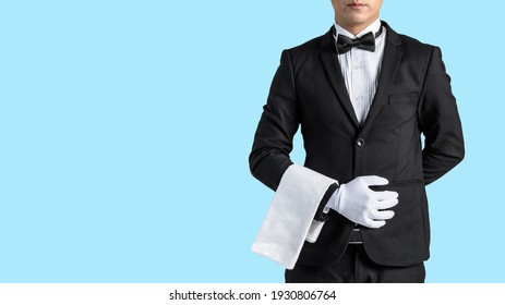 Handsome waiter in tuxedo and gloves holding empty tray and napkin whit dicut part.