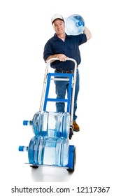 Handsome Water Delivery Man With A Five Gallon Jug On His Shoulder And Two More In The Dolly.  Full Body Isolated On White.