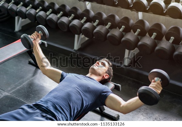 Handsome Weightlifter Lifting Bench Press Working Stock Photo
