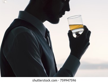 Handsome Well Dressed Professional Man Silhouetted Profile Holding A Neat Whiskey Scotch Drunk Backlit In White. 