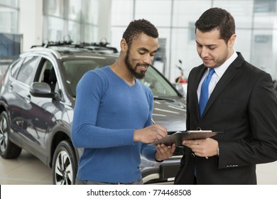 Handsome Young African Man Buying A New Car Signing Documents With A Professional Salesman Contract Agreement Deal Renting Signature Buyer Consumerism Lifestyle Luxury Automobile Vehicle Insurance