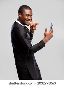 handsome young african man feeling excited and happy viewing content on his phone