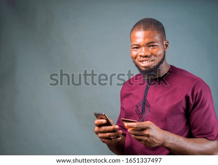 Similar – African man blue background with mobile phone.