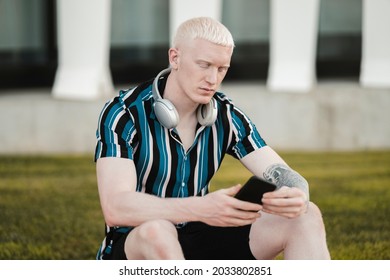 handsome young albino man using smartphone - Powered by Shutterstock