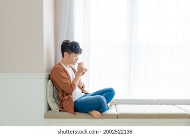 Handsome Young Asian Man Drinking At Home