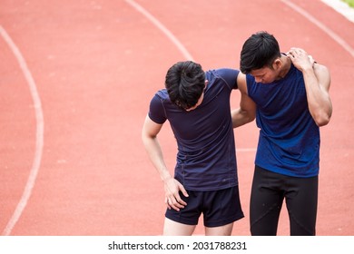 A handsome young Asian man injured the racetrack at the stadium after exercise while being helped by his friend. Concepts of health, sports healthcare and medical. - Powered by Shutterstock