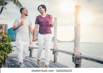 Handsome Young Attractive Male Couple, Gay Couple And Family, Valentine's Day At A Tropical Resort, Walk Along The Beach Holding Hands