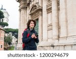 Handsome young backpacker with a camera