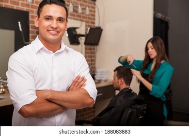 Handsome Young Barber Shop Owner Smiling And Managing His Business