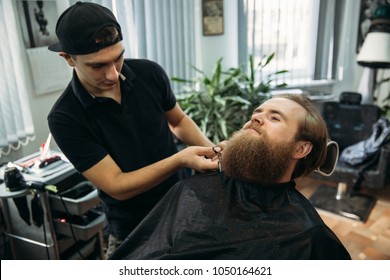 handsome young bearded guy sitting in an armchair in a beauty salon