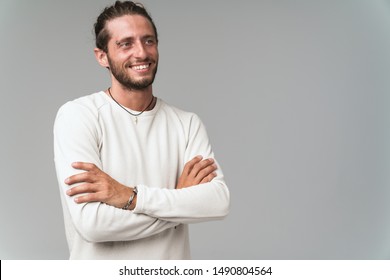Handsome young bearded guy wearing casual clothing isolated over gray background, arms folded - Shutterstock ID 1490804564