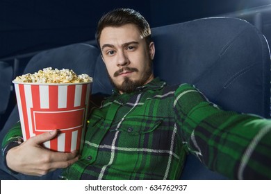 Handsome Young Bearded Man Holding His Popcorn Bucket Sitting At The Movie Theatre Making A Selfie While Watching A Film Copyspace Social Media Teen People Lifestyle Entertainment Leisure Activity