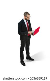 Handsome Young Bearded Man Standing At White Studio Background With Laptop. Full Body Portrait Of Businessman. Serious Young Man In Glasses, Suit, Red Tie. Business, Career, Success Concept.