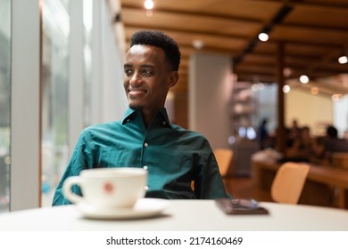 Handsome Young Black Man In Coffee Shop Looking Through Window