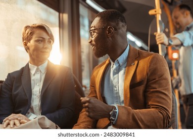 Handsome, young black man talking to a blonde, white woman on a bus while they sit next to each other. - Powered by Shutterstock