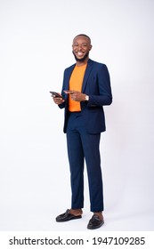 Handsome Young Black Man Wearing A Suit Using His Phone And Credit Card, Standing On A White Background