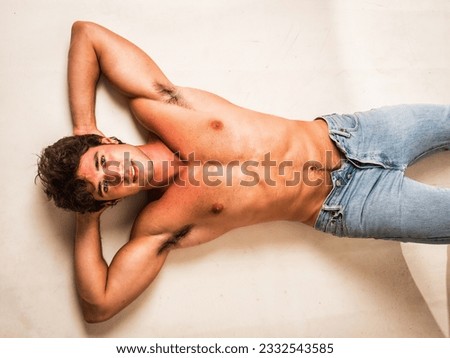 Handsome young bodybuilder laying down on the floor