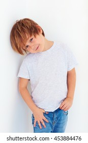 handsome young boy, kid posing near the white wall