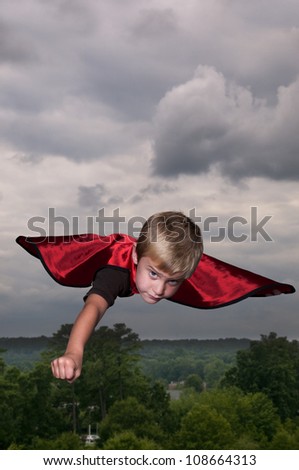 Handsome young boy super hero flying through the sky