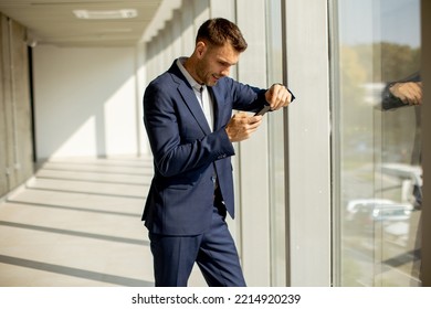 Handsome Young Business Man Using Mobile Phone In The Modern Office Hallway