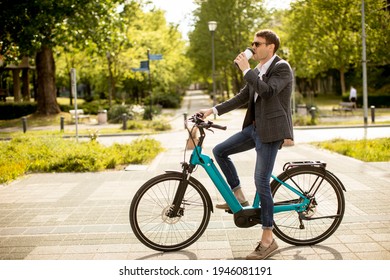 Handsome young businessman on the ebike with takeaway coffee cup - Powered by Shutterstock