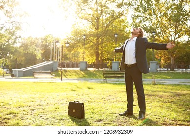 Handsome young businessman resting in park