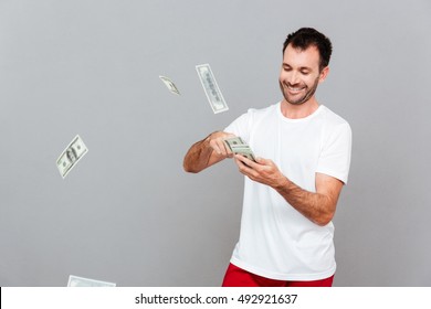 Handsome Young Casual Man Counting Money Over Gray Background