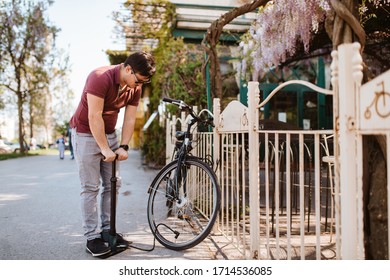 Handsome young caucasian man pumps a bicycle tire - Powered by Shutterstock