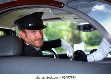 Handsome Young Chauffeur In Limousine, Smiling.