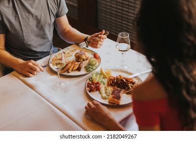 Handsome young couple having lunch with white wine in the restaurant - Powered by Shutterstock