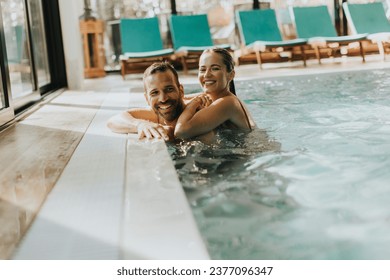 Handsome young couple relaxing in the indoor swimming pool - Powered by Shutterstock