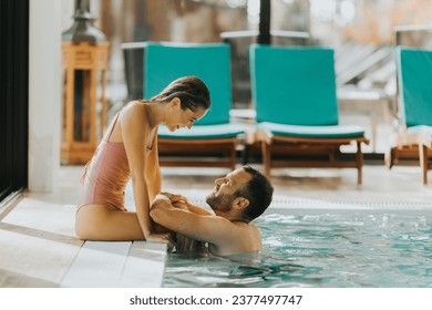 Handsome young couple relaxing in the indoor swimming pool - Powered by Shutterstock