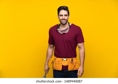 Handsome Young Craftsman Over Isolated Yellow Background