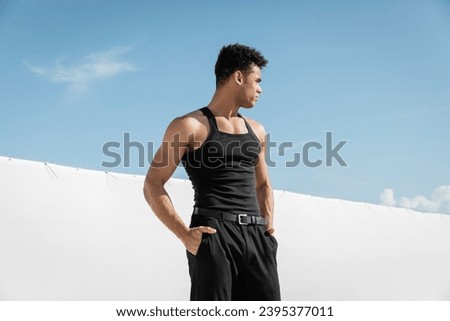 handsome young cuban man in black sleeveless t-shirt and pants posing in Miami, south beach