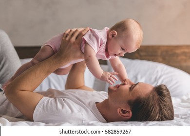 Handsome Young Dad Is Playing With His Cute Baby And Smiling