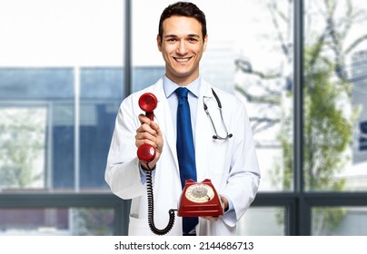 Handsome Young Doctor Portrait Holding A Red Old Fashioned Phone