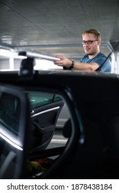 Handsome Young Driver Getting Ready To Go Biking - Putting A Bike Rack On The Roof Of His Car