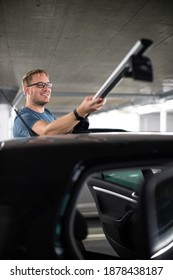 Handsome Young Driver Getting Ready To Go Biking - Putting A Bike Rack On The Roof Of His Car