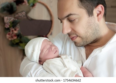 Handsome Young Father Hold His Newborn Baby Boy After In Hospital.  Newborn Baby In Delivery Room. Parent And Infant First Moments Of Life. Happy Father's Day Concept.