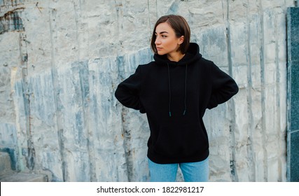 Handsome young female wearing black blank hoodie with space for your logo or design. Mockup for print