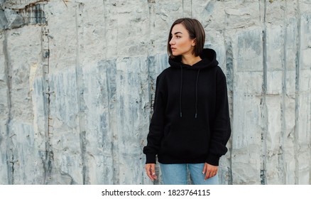 Handsome young female wearing black blank hoodie with space for your logo or design. Mockup for print