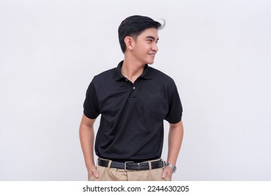 A handsome young filipino man with ear studs in a black polo shirt looking to his right. Isolated on a white background. - Powered by Shutterstock