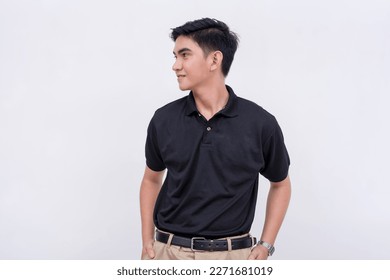 A handsome young filipino man with ear studs in a black polo shirt looking to his left. Isolated on a white background. - Powered by Shutterstock