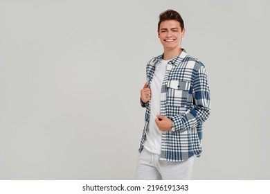 Handsome Young Happy Man Posing In  Fashionable Shirt, Smiling And Looking At The Camera. Student. Studio Shot. Grey Background. Copy Space. Real People Emotions.
