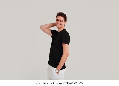 Handsome Young Happy Man Posing In Black Fashionable Shirt, Smiling And Looking At The Camera. Student. Studio Shot. Grey Background. Copy Space. Real People Emotions.
