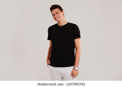 Handsome Young Happy Man Posing In Black Fashionable Shirt, Smiling And Looking At The Camera. Student. Studio Shot. Grey Background. Copy Space. Real People Emotions.
