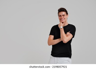 Handsome Young Happy Man Posing In Black Fashionable Shirt, Smiling And Looking At The Camera. Student. Studio Shot. Grey Background. Copy Space. Real People Emotions.
