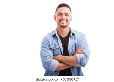 Handsome young Hispanic guy smiling with his arms crossed against a white background - Shutterstock ID 333000917