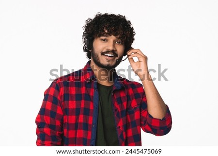 Handsome young Indian man in dispatcher headset talking with clients online isolated over white background. Hindi It-support manager hotline worker portrait